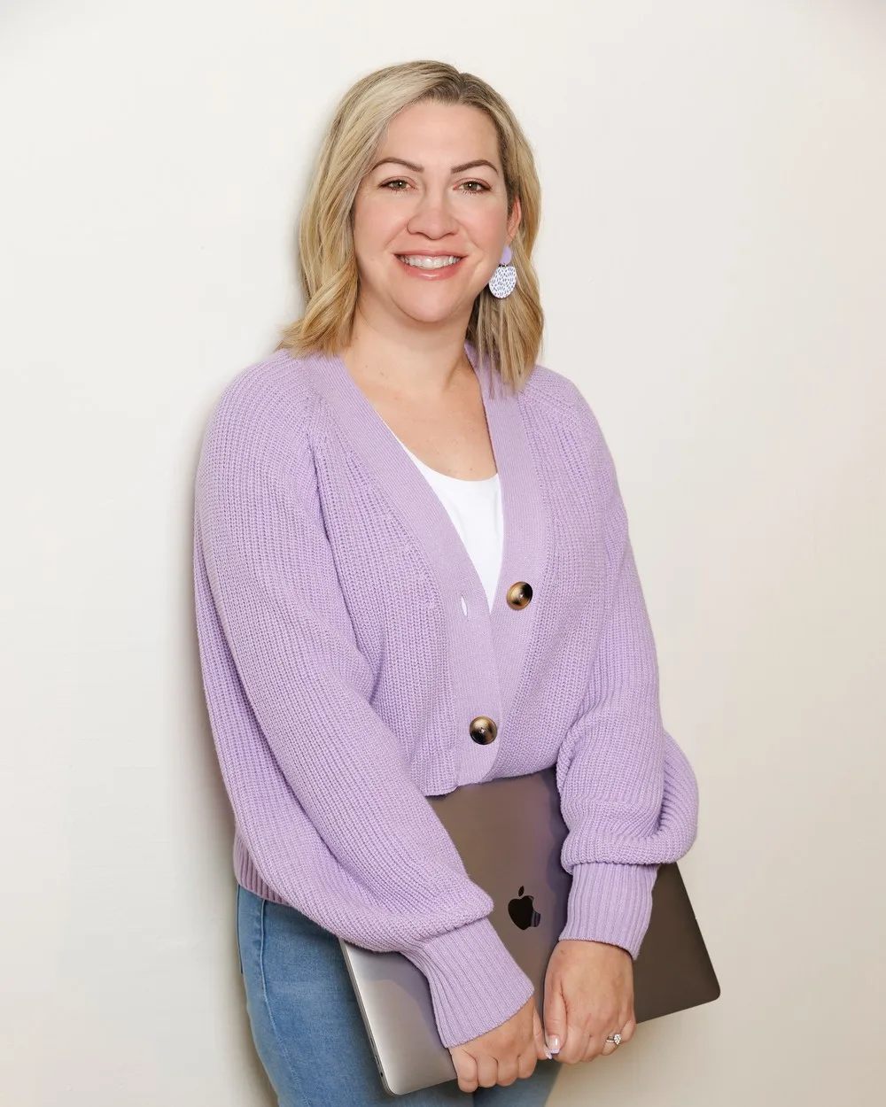 Carly, founder of Hatched Designs, holding a laptop