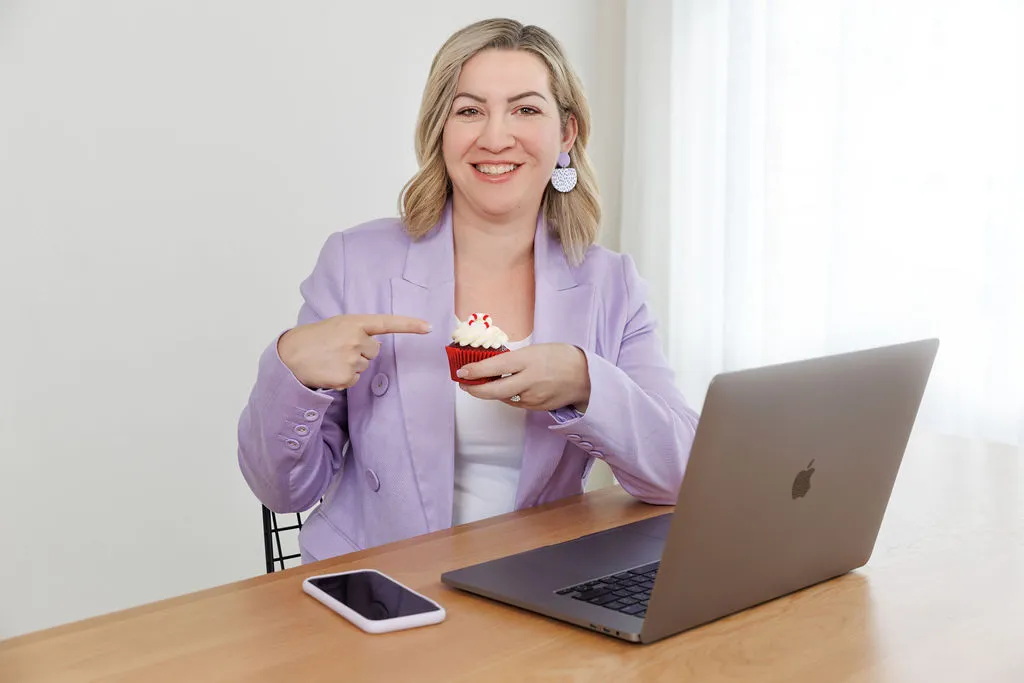 Carly from Hatched Designs at her laptop, ready to help with your WordPress website